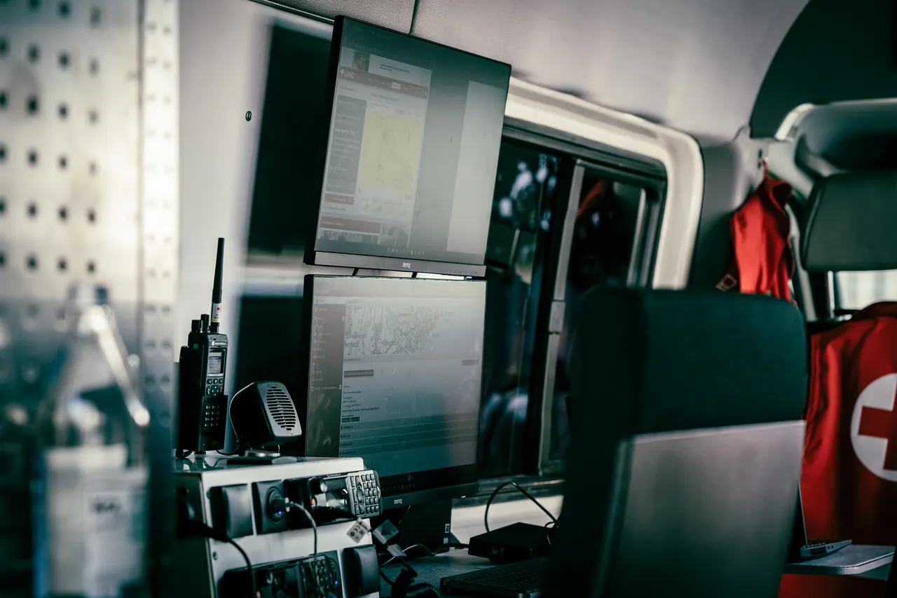 Arbeitsplatz in einem Kommandofahrzeug mit Monitoren, Funkgeräten und Lagekarte