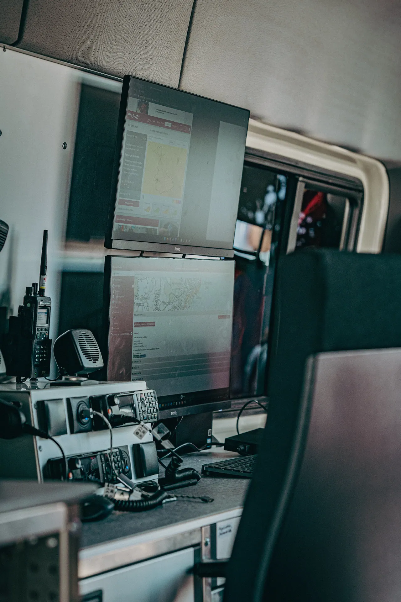 Monitore und Funkgeräte im Kommandofahrzeug, Blick über die Sitzlehne