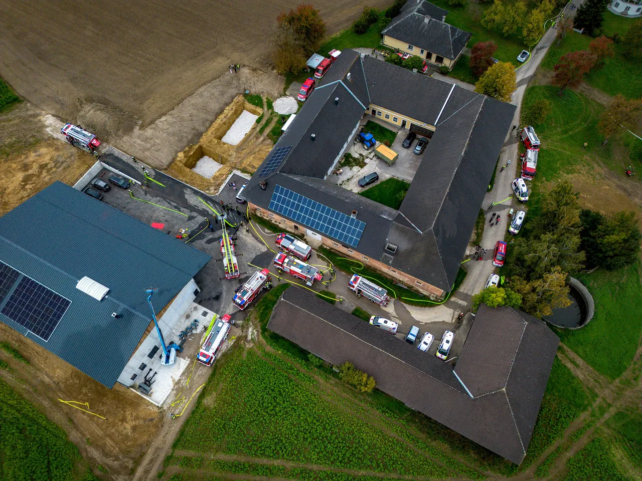 Luftbild einer gemeinsamen Übung von Feuerwehr und Rettungsdienst auf einem Bauernhof